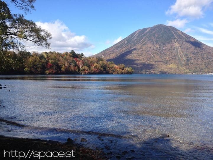 autumn leaves on Lake Chuzeji at Nujina Peninsula with Nantai Mountain in the background.