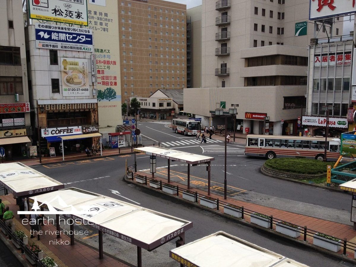 A Narita Airport bus stops at a busy street.