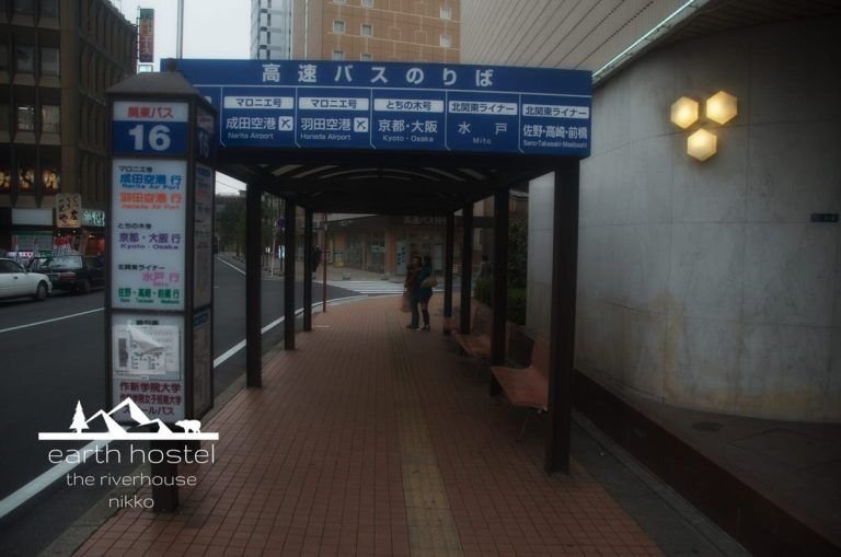 A sidewalk with a bus stop sign near Narita Nikko Airport.