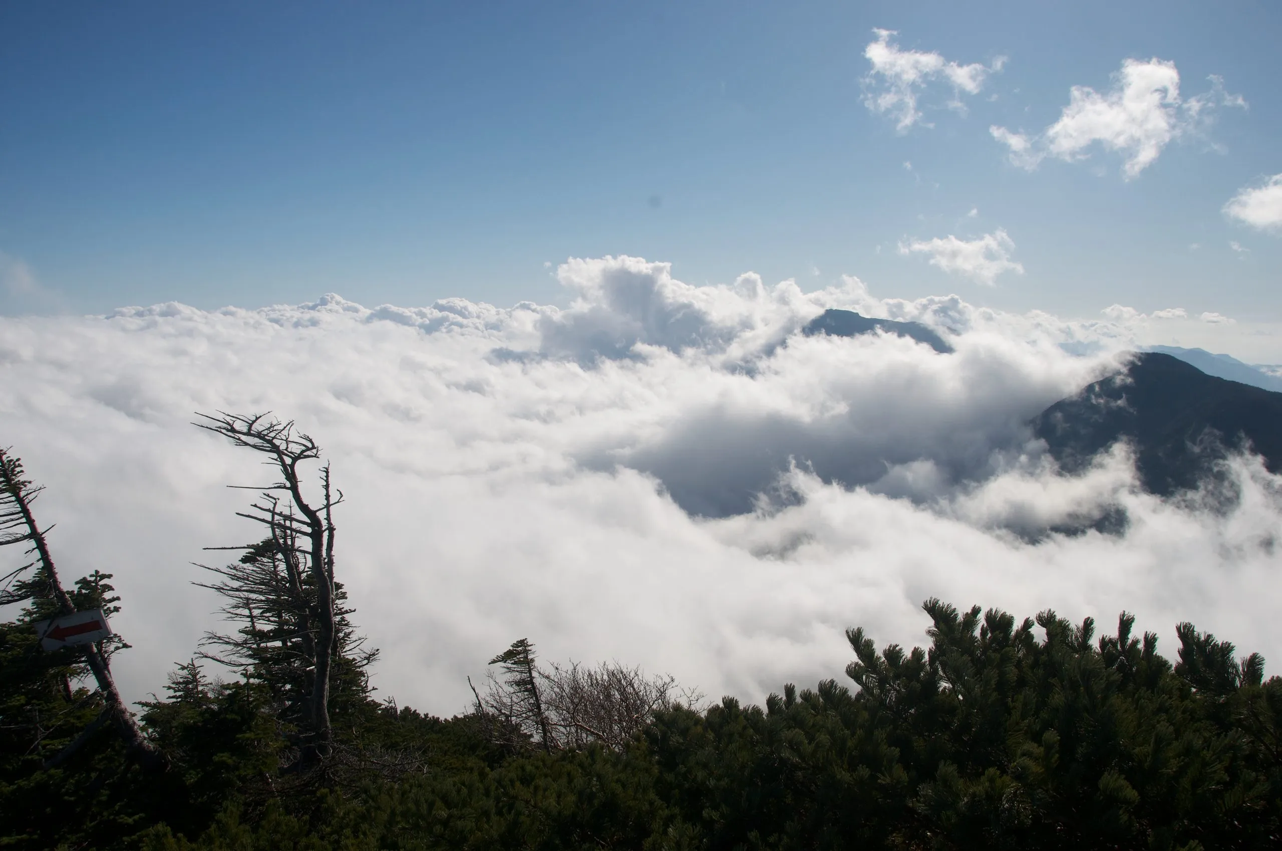 Sea of clouds and distant peaks seen from the summit ridge, Nyoho Mountain hiking trail, Nikko Japan