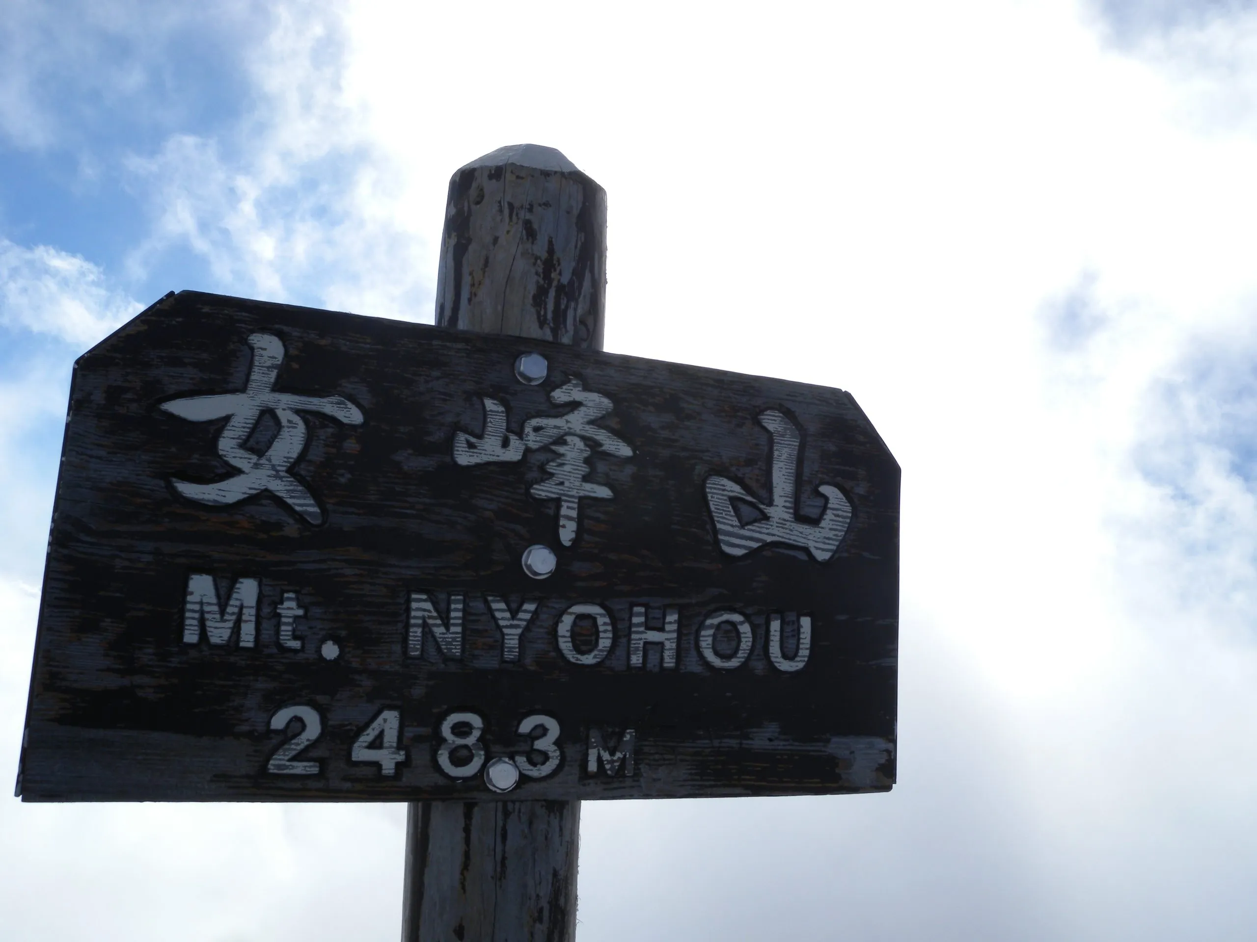 Summit marker reading Mt. Nyohou 2483m, Nyoho Mountain hiking trail, Nikko Japan