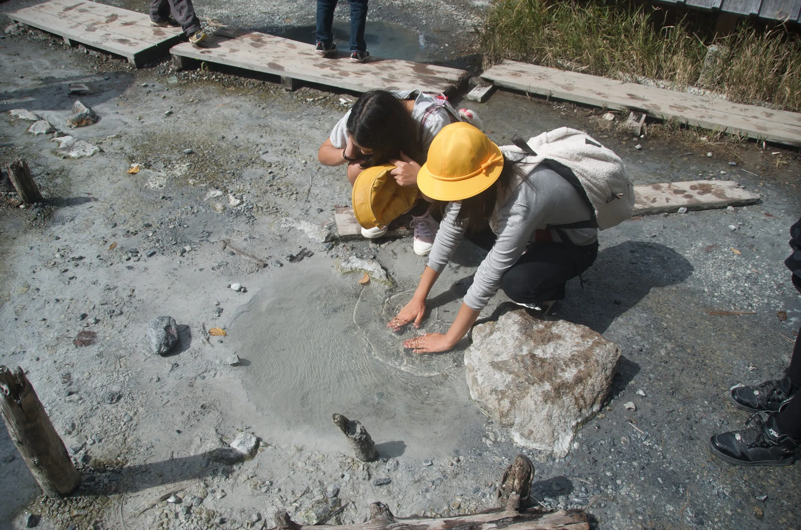 Children touching warm hot spring water at Yumoto Onsen source, Nikko Japan
