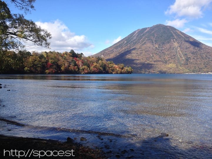 autumn leaves on Lake Chuzeji at Nujina Peninsula with Nantai Mountain in the background.