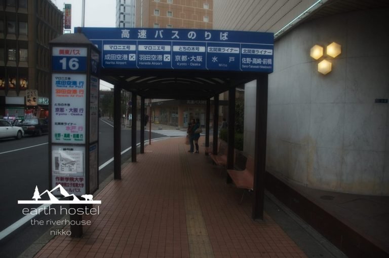 A sidewalk with a bus stop sign near Narita Nikko Airport.