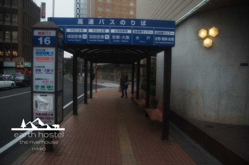 A sidewalk with a bus stop sign near Narita Nikko Airport.