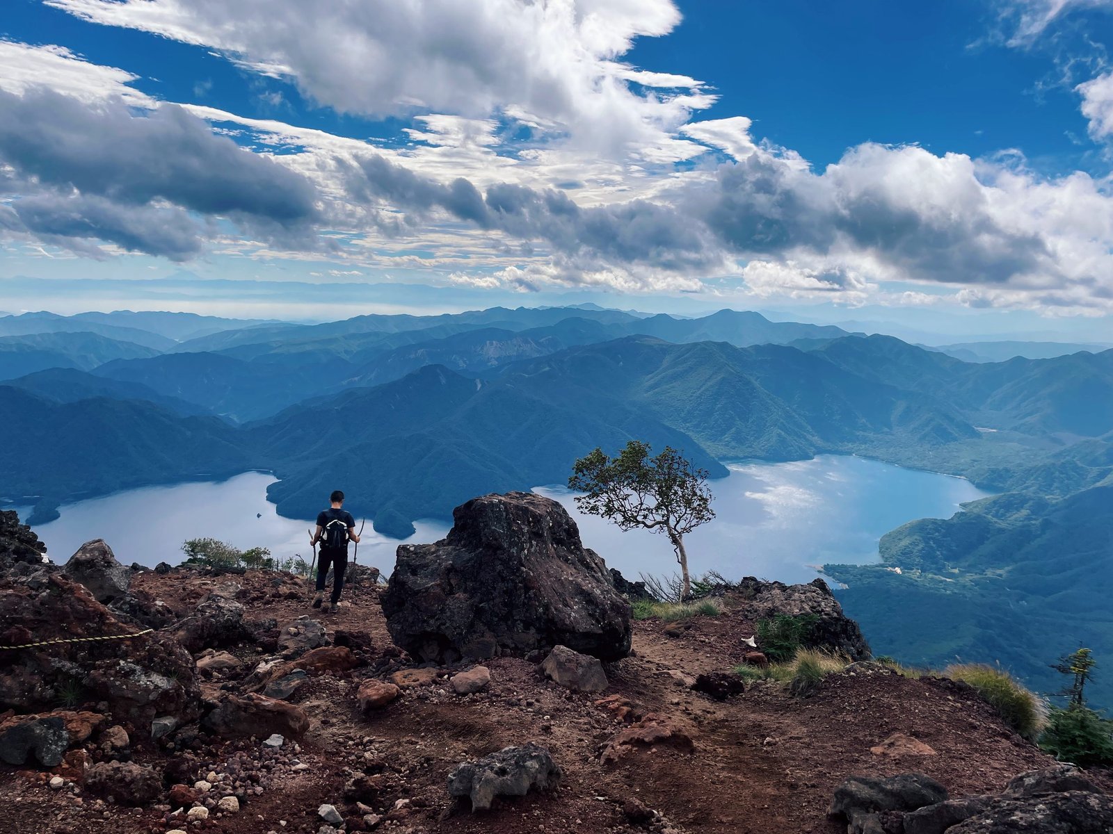 Hiker on the summit of Nantai looking down at Lake Chuzenji, Nikko Japan